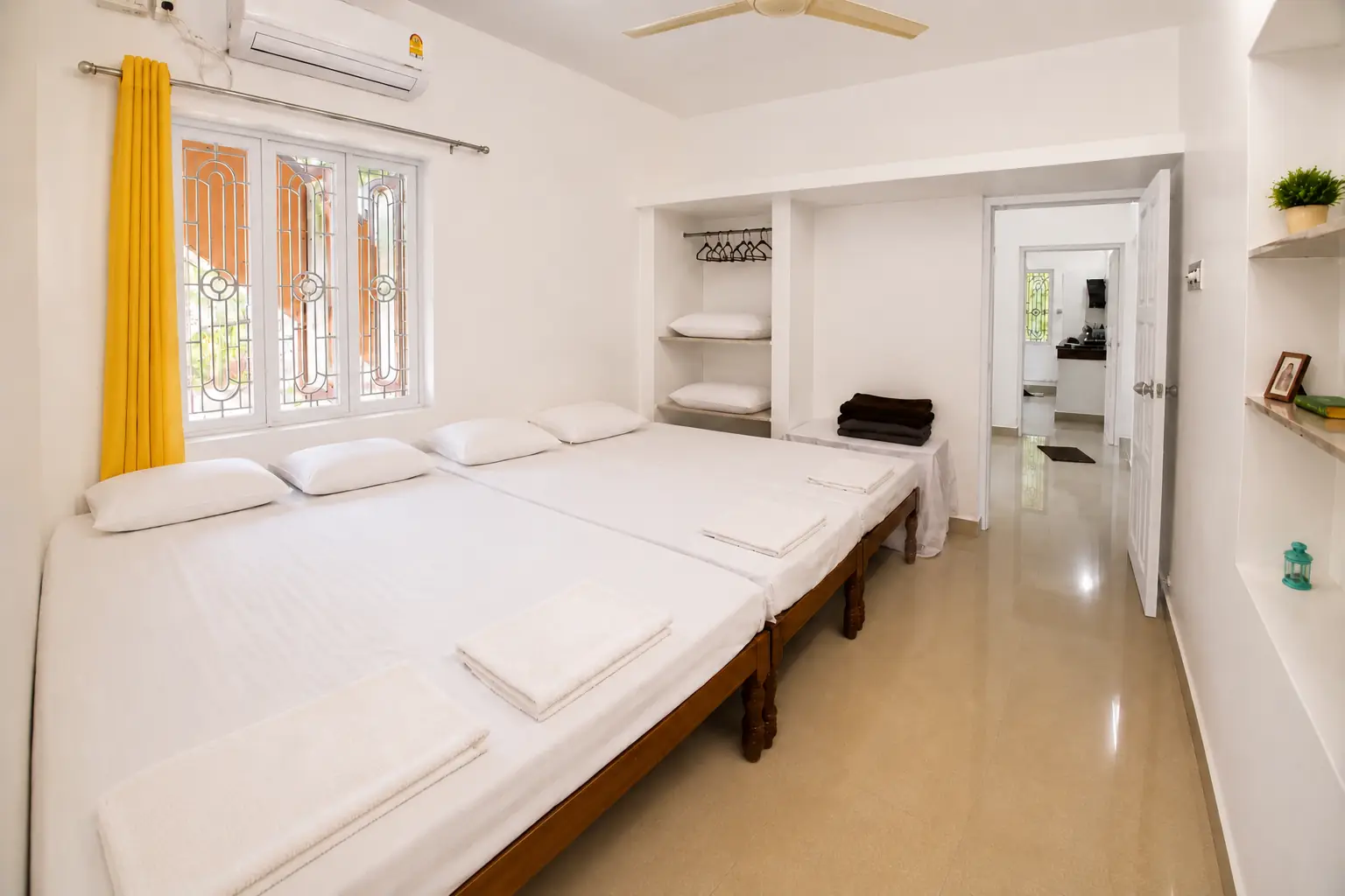 Reverse bedroom view with shelves and connecting doorway in Nidhi apartment.