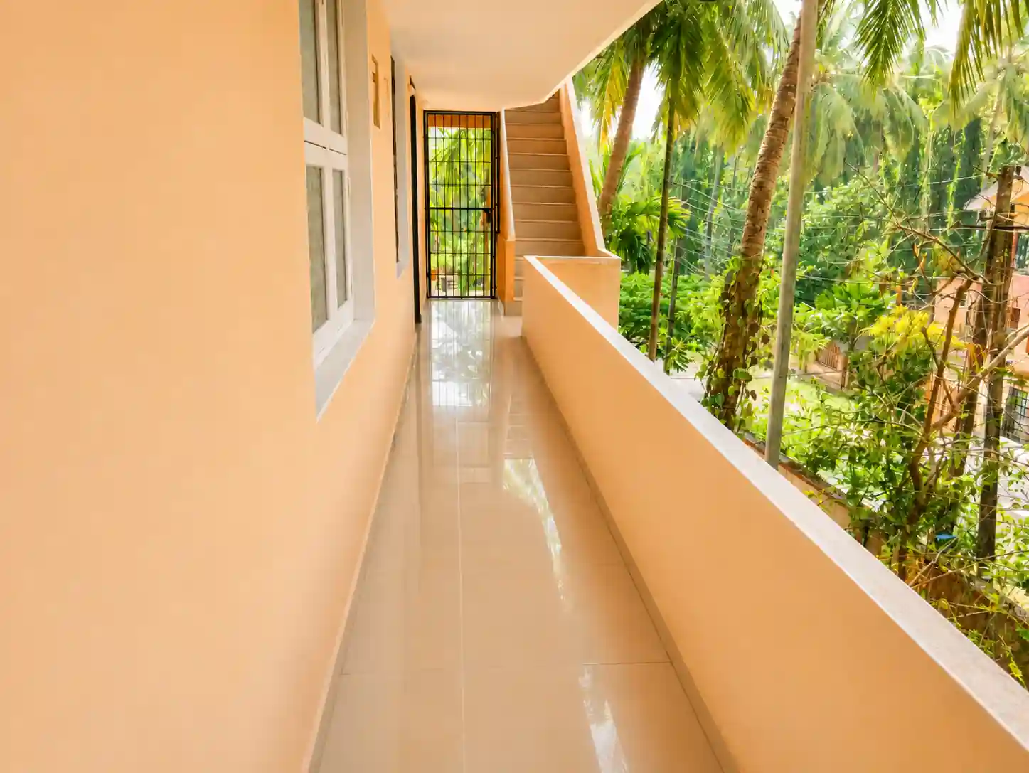 Open first-floor corridor with gate and stairs visible at the far end.