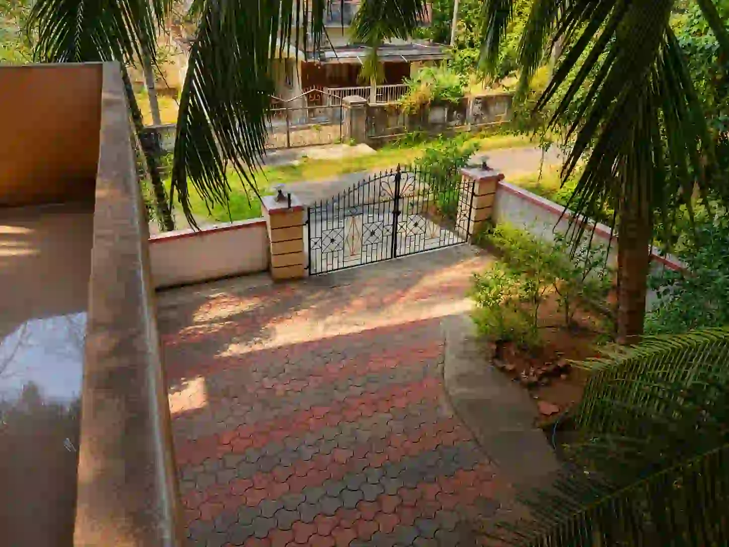 Elevated view of paved courtyard and entrance gate at Balakrishna Udupi Homestay.