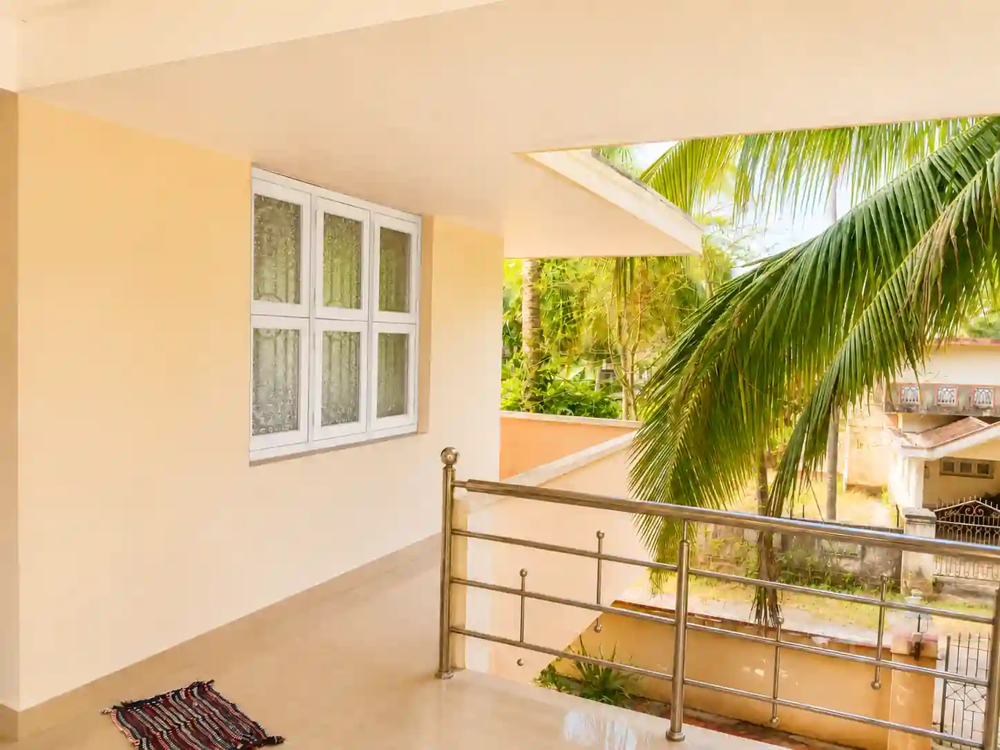 Open passage beside windows and railing at Balakrishna Udupi Homestay.