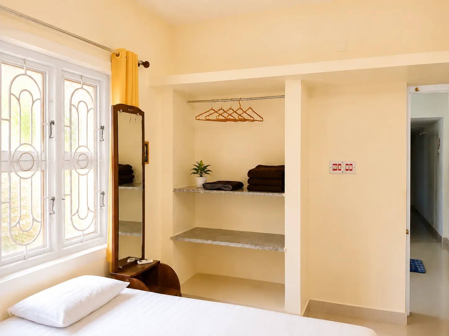Bedroom storage shelves, mirror and doorway to sit-in room in SriNidhi apartment.