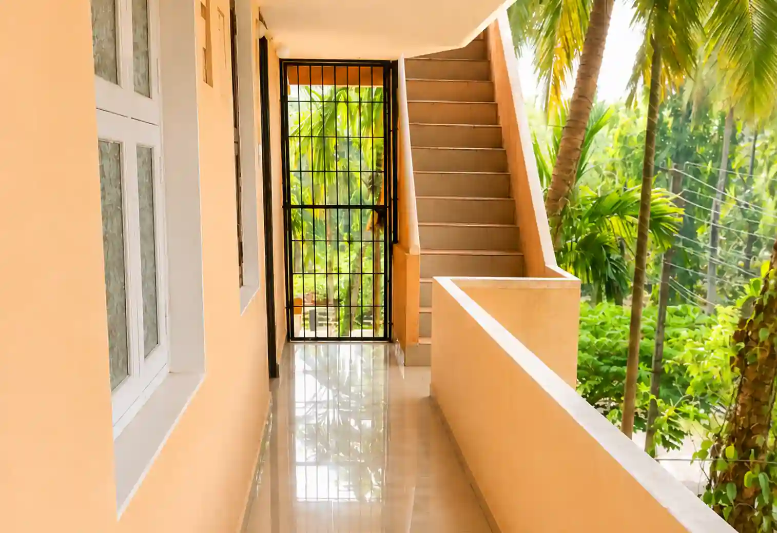 Upper passage with metal gate and ascending stairs at Balakrishna Udupi Homestay.