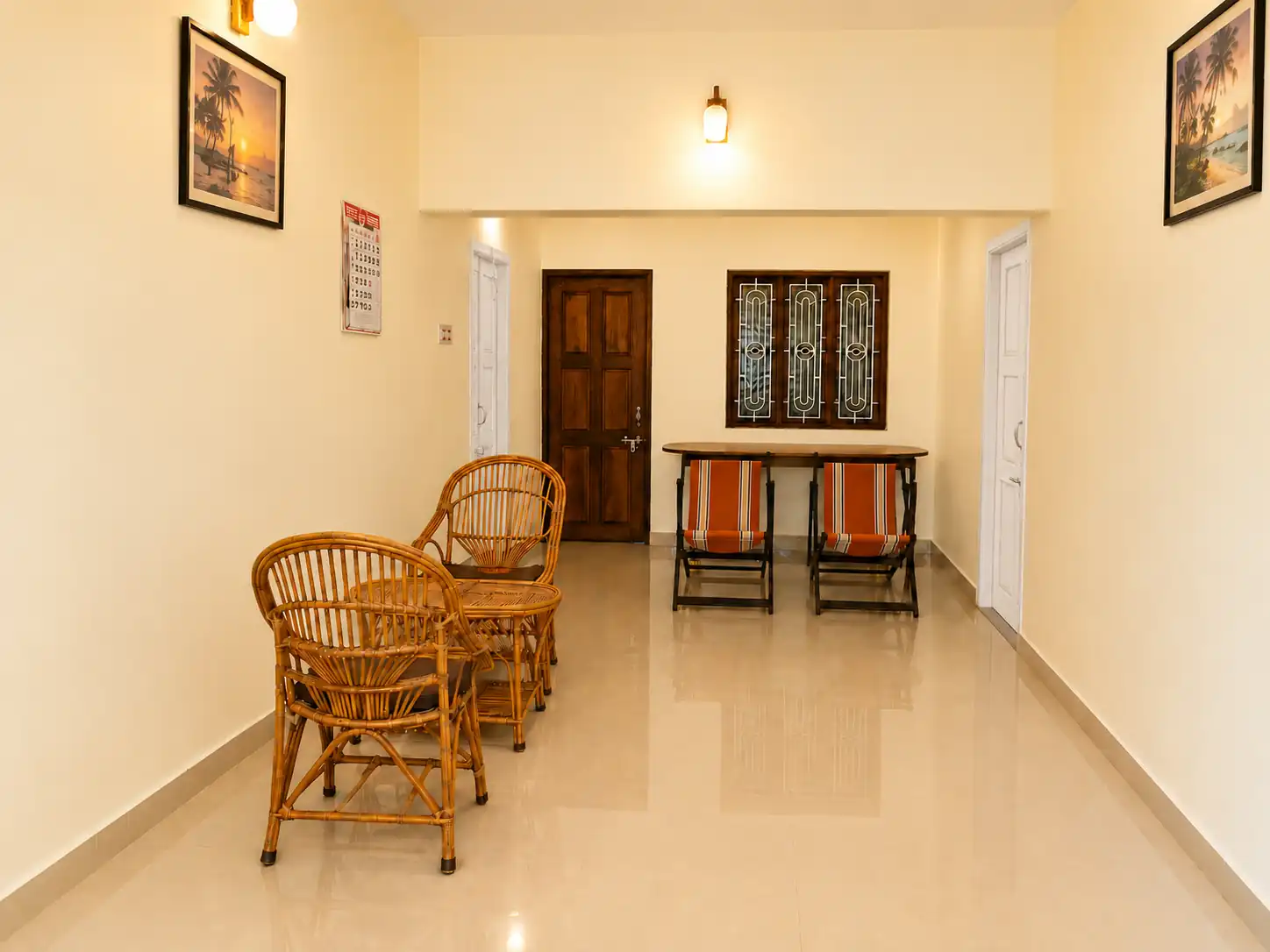 Central hall viewed from the balcony, with cane seating, apartment doors and a rear window.